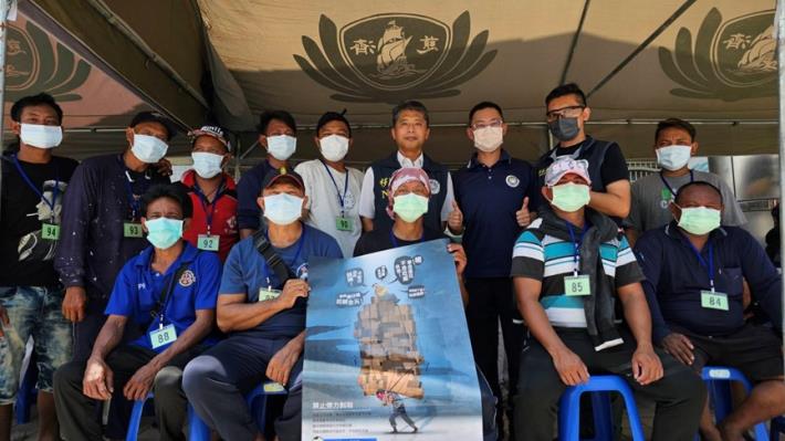 內政部移民署國境事務大隊同仁於義診義剪活動中，向外籍船員宣導防制人口販運政策。