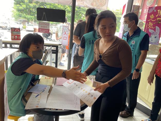 圖2：越南新住民紅青(右一)領取模擬選票後，在嘉義市選舉委員會人員引導下，前往圈票處模擬圈選心目中的候選人。.JPG
