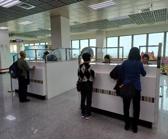 搭乘包機前往越南河內的旅客於金門尚義機場出境查驗櫃檯等候查驗通關。