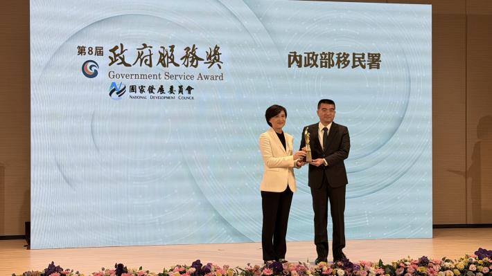 行政院副院長鄭麗君（左）頒發獎盃予移民署署長林宏恩（右）