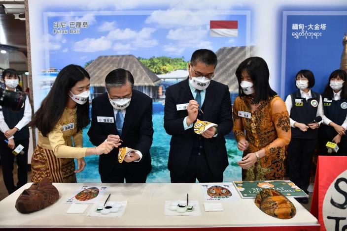 Minister Hsu Kuo-Yong carefully painted the eyes of the traditional Indonesian tiger face mask.