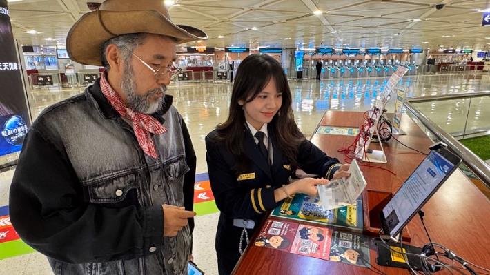 Immigration officers at the airport assist travelers with completing the TWAC and distribute promotional postcards