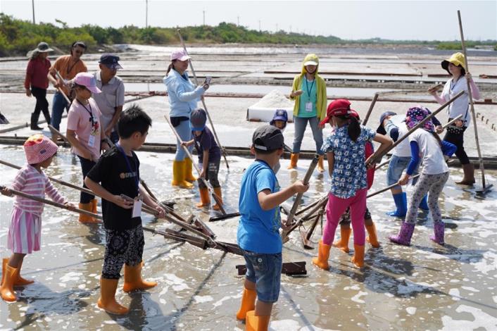 Senior salt workers guide the public to experience the process of drying salt