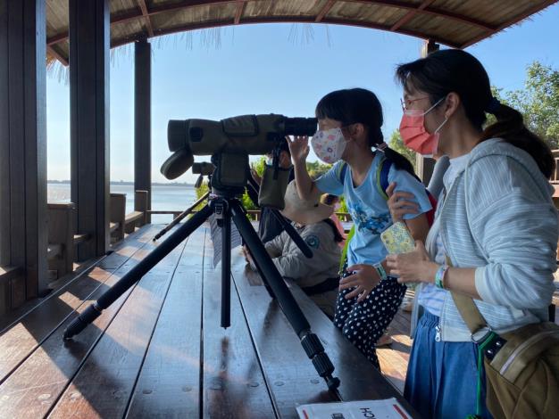 Tourists on the Commentary Shuttle Bus observing black-faced spoonbills and other winter migrants through the monoculars prepared by Taijian Administration.