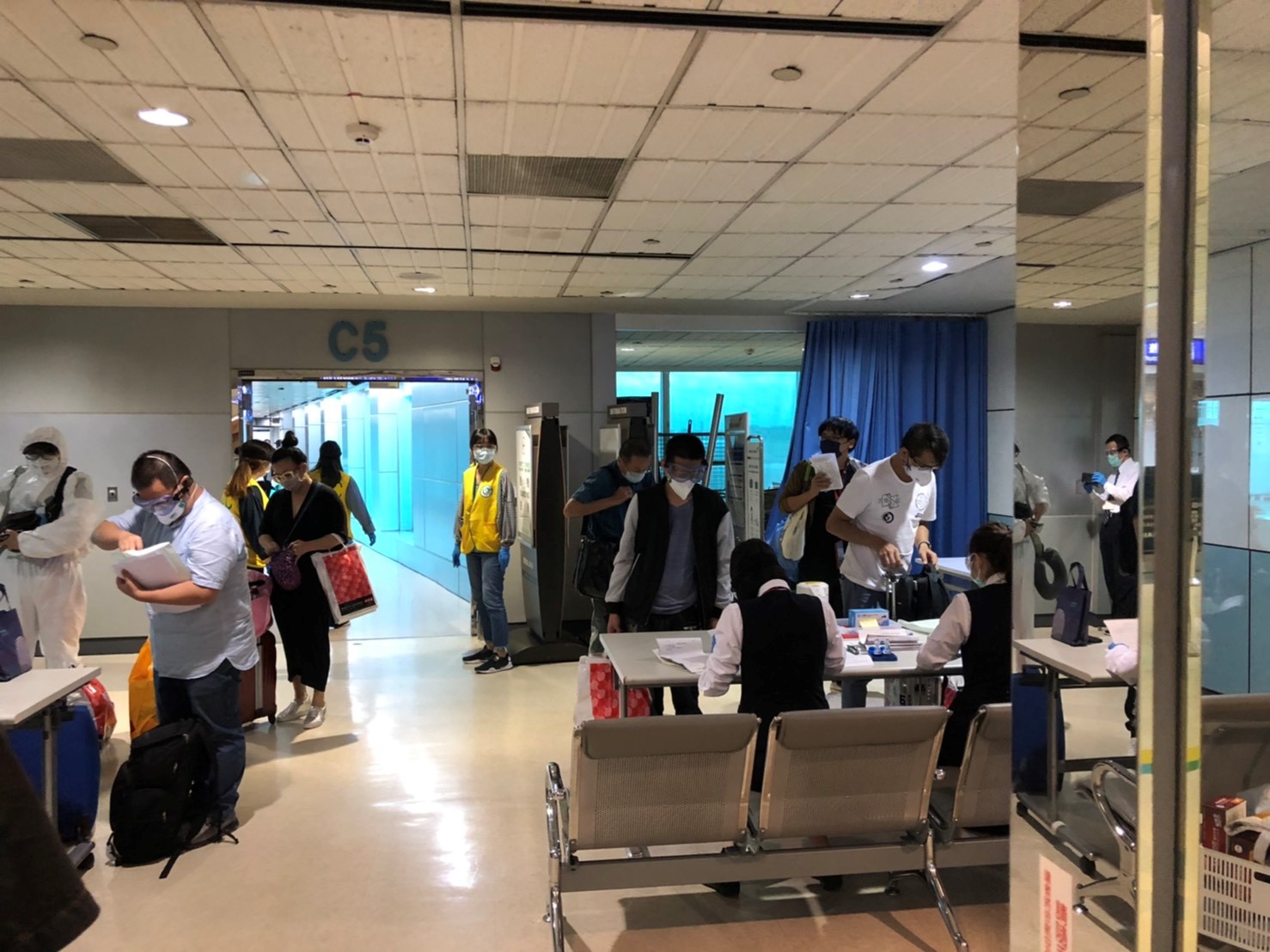 旅客於登機門接受檢疫人員健康評估