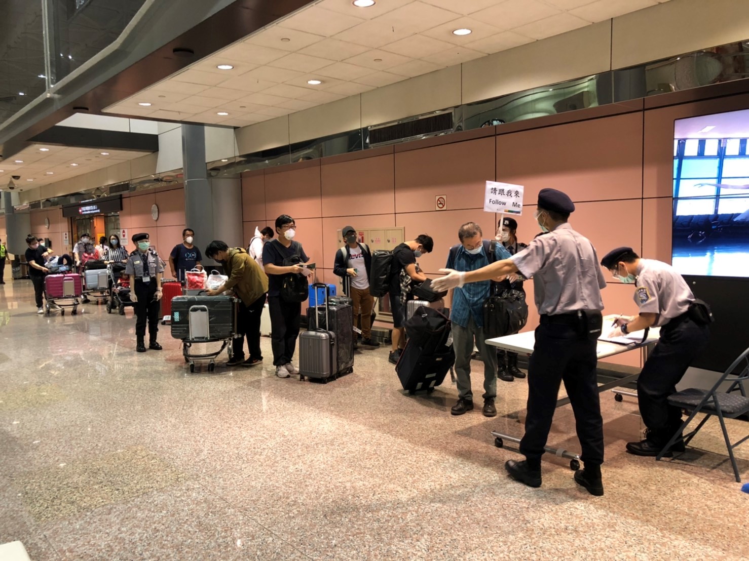 旅客於入境大廳等候搭乘防疫巴士