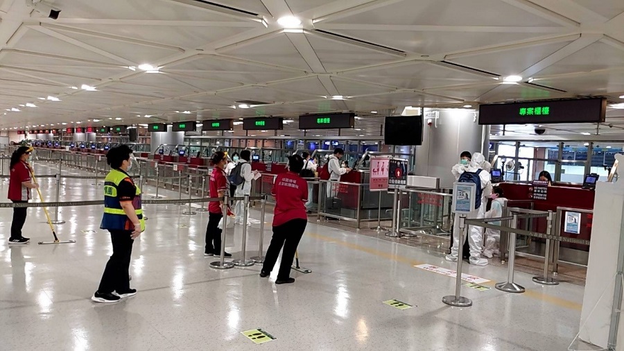 身著防護衣的旅客等待入境查驗通關