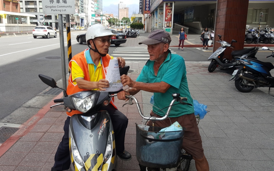 臺北市中正區幸福里里長蘇宏仁(左)服務40年，在颱風前走動式服務，騎車跟里民宣導防颱資訊