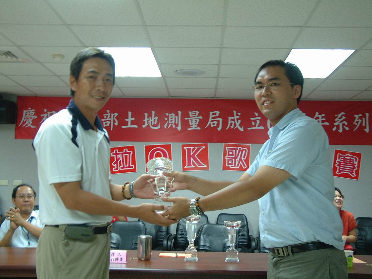 裁判長陳邦宇老師〈右〉頒贈第三名獎盃予第三測量隊彭玉書
